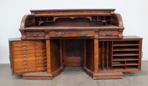 A late Victorian mahogany and walnut roll top desk, the rectangular top with chamfered edge with