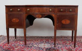 An Edwardian mahogany sideboard, the shaped top above three drawers and two cupboards on square