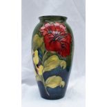 A Moorcroft pottery vase with a graded green to blue ground decorated in the Hibiscus pattern,