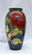 A Moorcroft pottery vase with a graded green to blue ground decorated in the Hibiscus pattern,