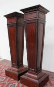 A pair of 19th century mahogany torchere, the square tops on tapering blind fret decorated sides