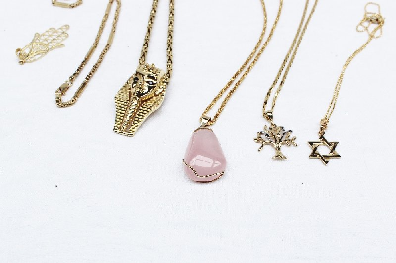 A rose quartz pendant on a 14ct yellow gold chain together with a 14ct yellow gold Egyptian pendant