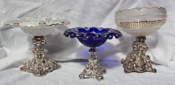 A continental white metal and blue glass table centrepiece, with a flared glass bowl, on an embossed