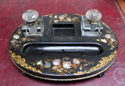 A Victorian papier mache desk standish of oval form on four turned feet,