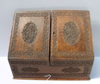 A carved Anglo Indian desk top stationery cabinet with a pair of sloping doors and a base drawer