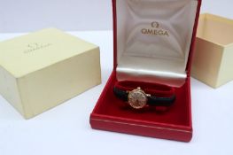 A lady's 9ct yellow gold Omega automatic wristwatch the silvered dial with batons to a leather