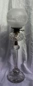 A Victorian glass oil lamp the later etched glass globe shade above a cut glass reservoir, the