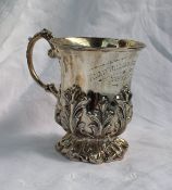 A late Victorian silver christening mug with a flared rim, cast with leaves on a spreading foot,