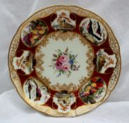 A Nantgarw porcelain plate painted with vignettes of birds, castles and fruit to a red ground, the