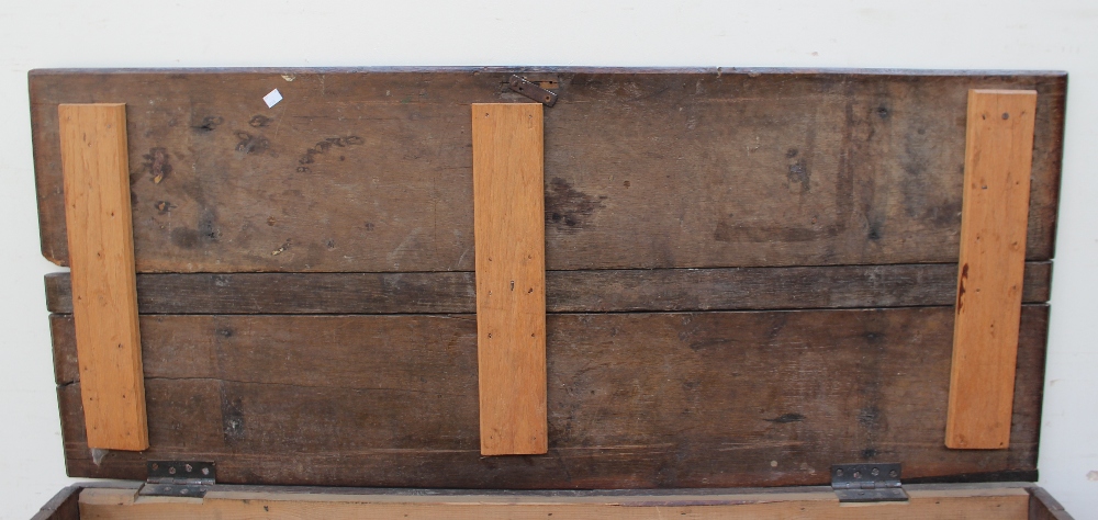 An 18th century oak coffer the planked rectangular top above an eight panel front on stiles, - Image 3 of 4