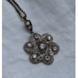 A Diamond pendant set with fifty one old cut diamonds in a floral setting,