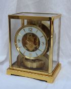 A Jaeger Le Coultre Atmos clock, the brass mounted glazed case with a white dial, Arabic numerals