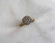 A diamond cluster ring set with nineteen old cut diamonds to a white metal rubbed over setting on a