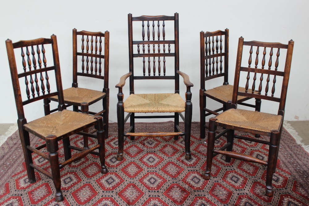 A set of five 19th century spindle back dining chairs with rush seats on tapering cylindrical front
