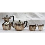 A George V silver four piece tea set of panelled form, comprising a hot water jug, teapot,