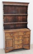 A late 19th / early 20th century oak North Wales type dresser the rack with a moulded cornice above