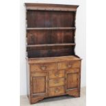 A late 19th / early 20th century oak North Wales type dresser the rack with a moulded cornice above