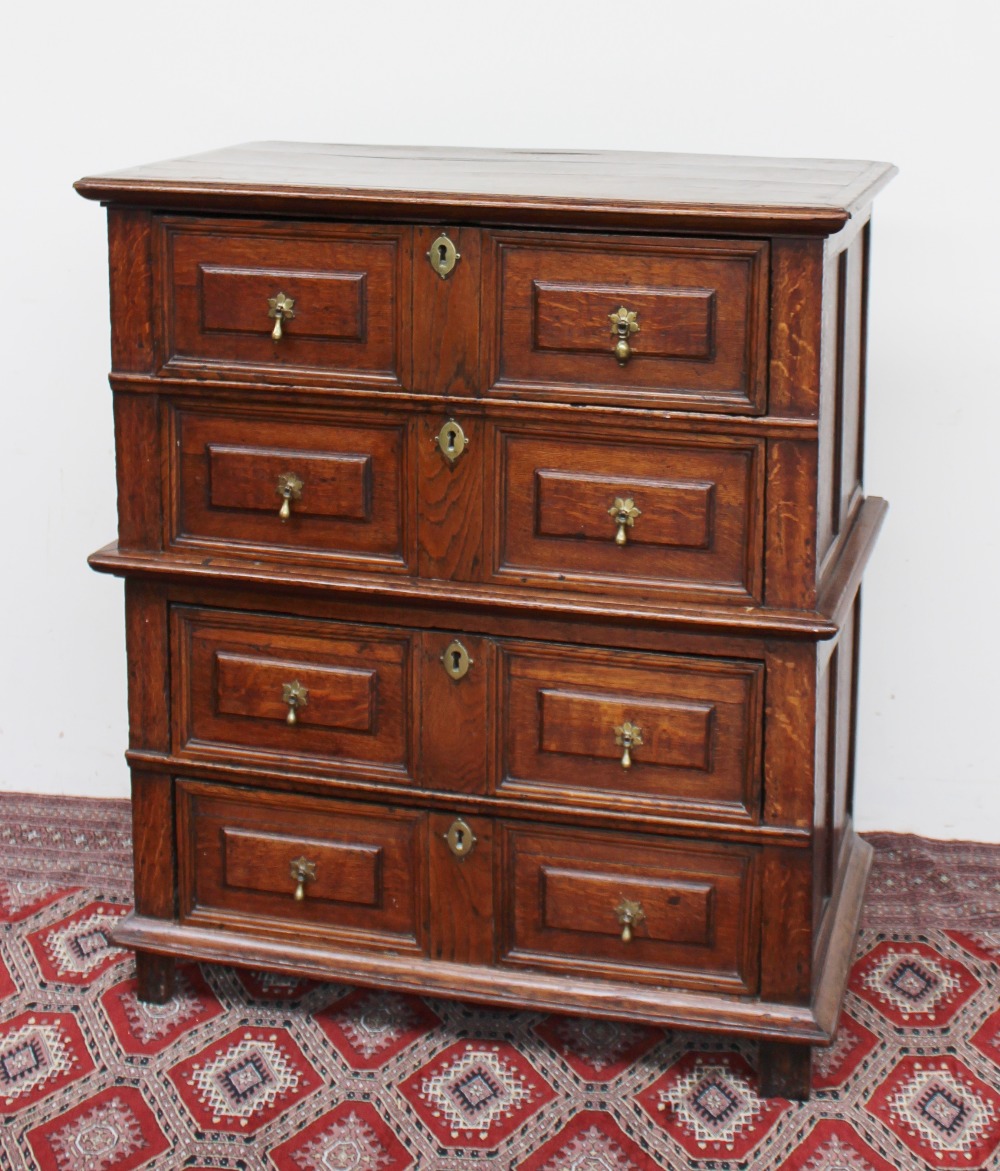 A 17th century style oak chest the planked moulded rectangular top above four drawers with geometric