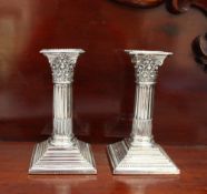 A pair of late Victorian silver stop fluted Corinthian column desk candlesticks,