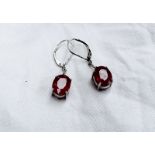 A pair of 18ct white gold pendant drop earrings set with faceted oval rubies