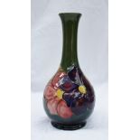 A Moorcroft pottery vase with a green ground decorated in the Clematis pattern, impressed mark and
