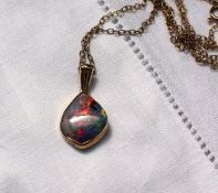 A fire opal mounted in 9ct yellow gold pendant on a 9ct yellow gold chain CONDITION REPORT: