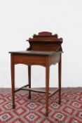 An Edwardian mahogany ladies writing desk with a raised superstructure above a leather inset