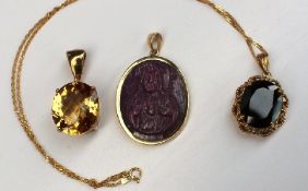 A 9ct yellow gold mounted ruby cameo pendant together with a citrine and white topaz pendant and