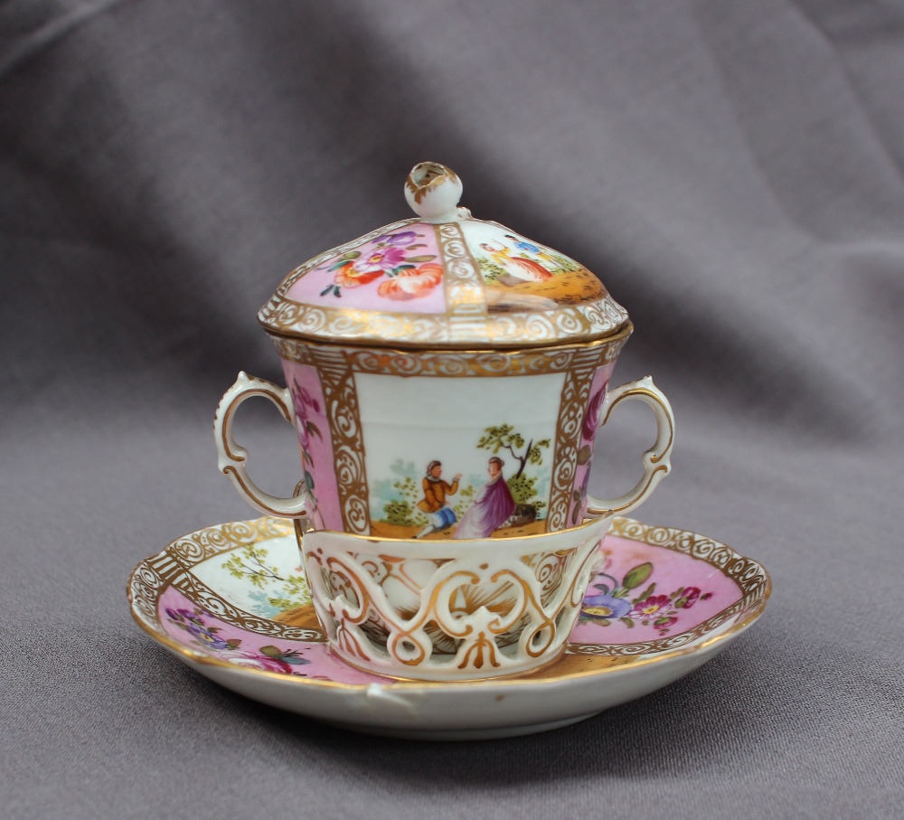 A 19th century continental twin handled chocolate cup, cover and saucer painted with panels of