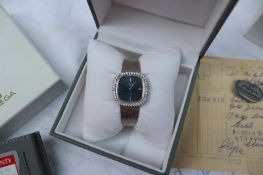 An 18ct white gold diamond set Omega De Ville lady's wristwatch, with a blue line decorated dial,