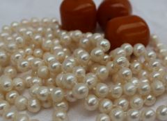 A long string pearl necklace with circa 105 individually knotted oval pearls,