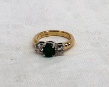 An Emerald and diamond ring, set with a central oval emerald approximately 0.