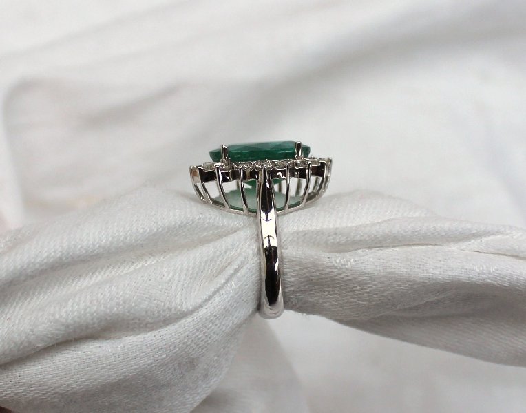 An emerald and diamond ring the central oval faceted emerald measuring 17mm x 13mm surrounded by - Image 2 of 4