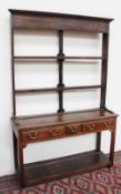 An 18th century style South Wales dresser, the open rack with a moulded cornice above two shelves,