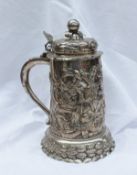 A continental white metal tankard, the domed lid with a fruit finial and embossed with fruit,