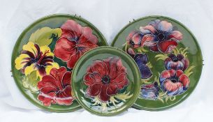 A Moorcroft pottery plate decorated in the Anemone pattern to a green ground, Impressed mark and