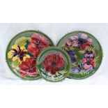 A Moorcroft pottery plate decorated in the Anemone pattern to a green ground, Impressed mark and