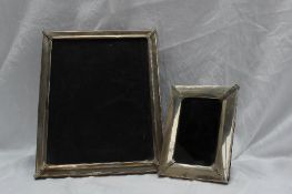 A continental white metal photograph frame of rectangular form with moulded corners,