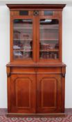 A Victorian mahogany bookcase, the moulded cornice above a pair of glazed doors,