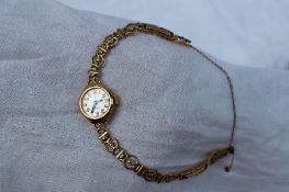 A 9ct yellow gold lady's excalibur  wristwatch, the silvered dial with Arabic numerals on a 9ct