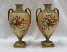 A pair of Royal Worcester porcelain twin handled vases painted with honeysuckle and other garden