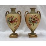 A pair of Royal Worcester porcelain twin handled vases painted with honeysuckle and other garden