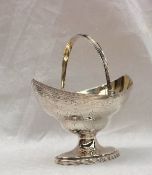 A George III silver swing handled pointed oval pedestal sugar basket, with a gilt interior,