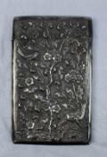 An oriental white metal card case of rectangular form embossed with flowers, leaves and birds,
