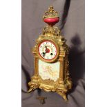 A 19th century French gilt metal mantle clock, with an urn finial decorated with grapes and leaves