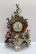 A continental porcelain mantle clock applied with cherubs emblematic of the four seasons,