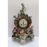 A continental porcelain mantle clock applied with cherubs emblematic of the four seasons,