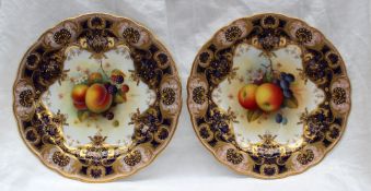 A pair of Royal Worcester porcelain cabinet plates, with a light pink and royal blue border with