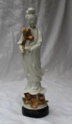 A Chinese Blanc-de-Chine figure of Guanyin, with flowing robes standing holding a lotus flower,