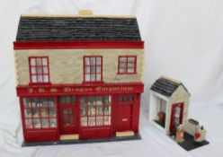 A scratch built dolls house in the form of a shop with a tiled roof,